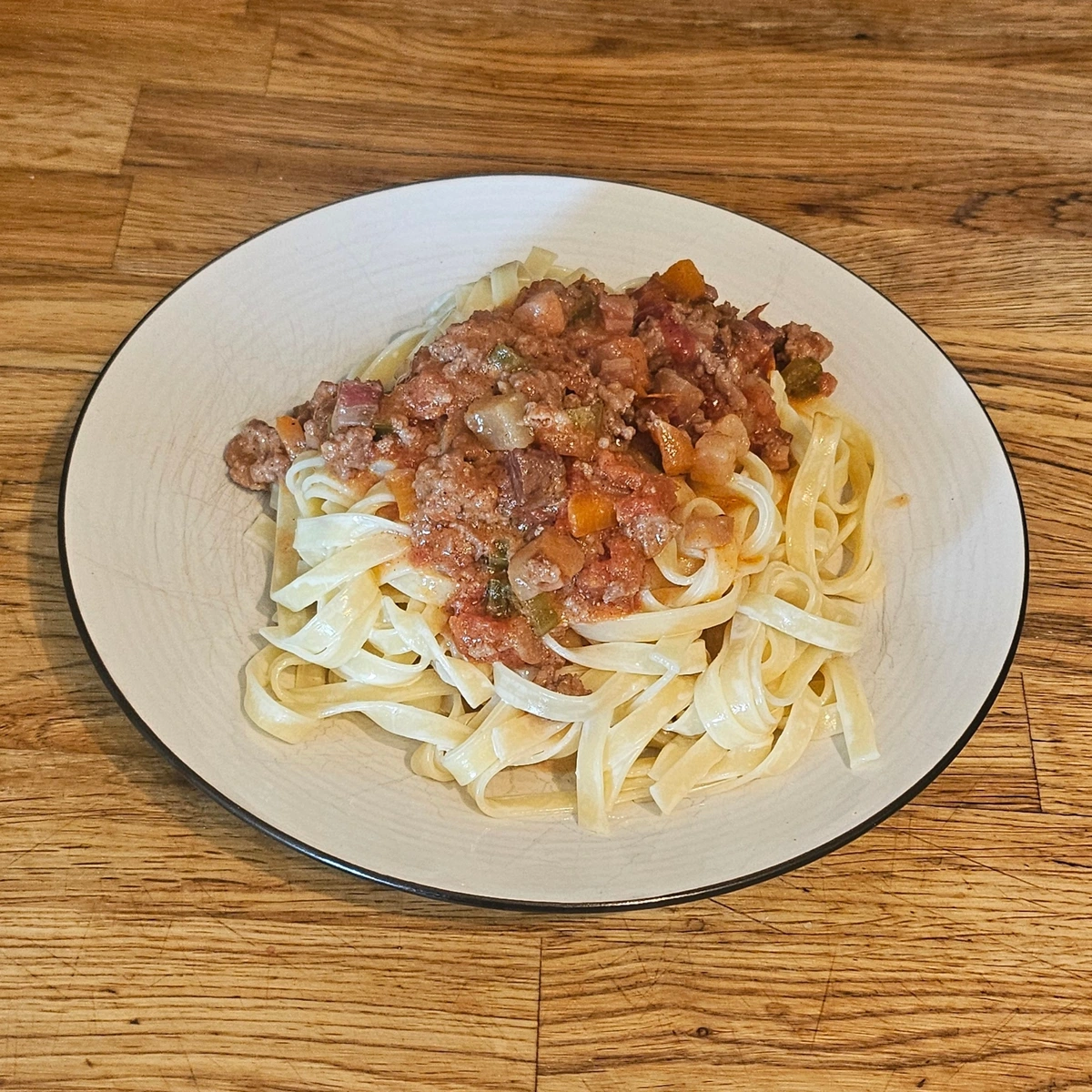 A plate of creamy pasta with bolognese sauce